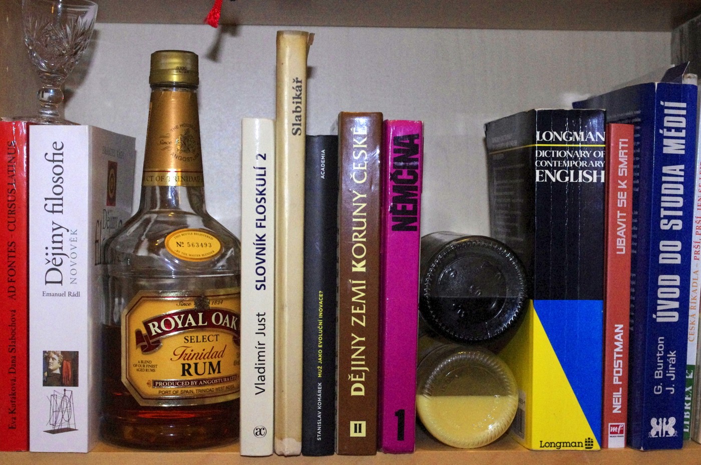 Nejenže mohou lahve s alkoholem ve vaší knihovně sloužit jako zarážky, i nudným knihám navíc dodávají chybějící barvu